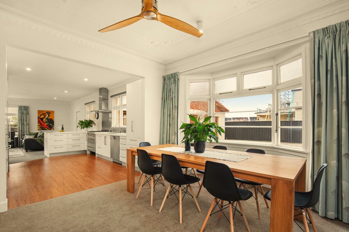 Dining table set for eight, opening to the kitchen